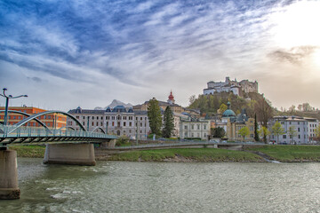 Salzburg old town skyline with river fortress and dramatic cloudy sky
