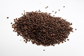 A pile of roasted coffee beans on a white background