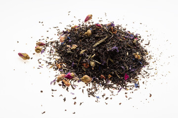 Ceylon tea with dried flower petals. A pile of black dry tea leaves on a white background
