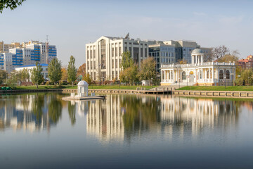 Obraz premium Swan Lake with central gazebo, Astrakhan, Russia, near Lukoil office and planetarium pavilion, calm water, autumn morning and urban park. 