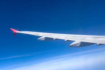 View from the airplane window at a beautiful cloudy sky and the airplane wing. Earth and sky as seen through window of an airplane. Travel concept. Copy space
