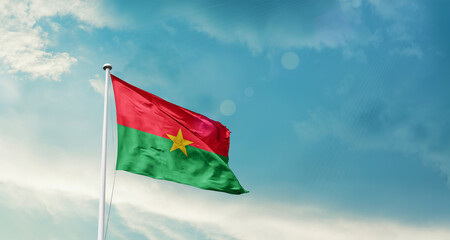 Burkina Faso national flag fluttering. The flag blowing in beautiful soft sky. Burkina Faso...
