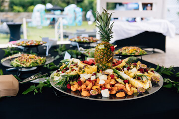 Colorful fruit platter with pineapple centerpiece at buffet
