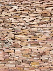 Textured sandstone wall. Stacked stones of various shapes and sizes create a strong decorative background in natural warm tones.