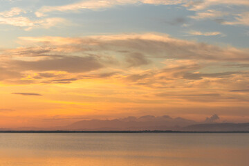 Scenic Sunset Over Calm Water and Mountains