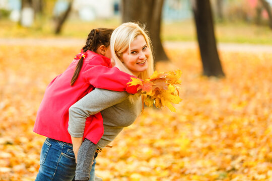 happy family mother and child daughter playing and laughing on autumn walk.