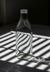 Glass bottle in intriguing chiaroscuro illumination with striped shadows