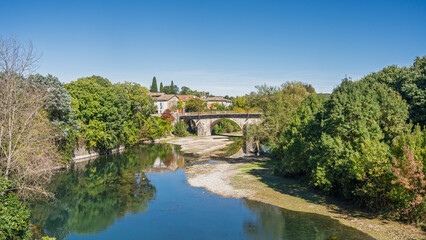 Scenic cityscape view of Vidourle river and the Pont Neuf or New Bridge in Sauve medieval village, Gard, France