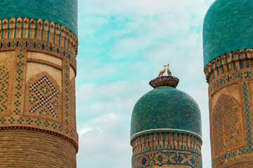 View on turquoise domes of Chor Minor madrasah against sky in Bukhara, Uzbekistan. Chor Minor or Madrasah of Khalif Niyaz-kul. Figures of storks in a nest on the roof. Built in 1807