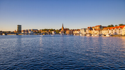 skyline with blue sky and evening sunlight in the danish city of Sonderborg, overlooking the promenade with sailboats.