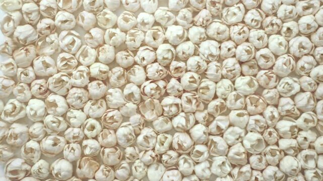 A bird's-eye view shows fresh white jasmine buds floating on shimmering water, an elegant natural backdrop suitable for spa wellness, aromatherapy, and beauty concepts, captured in slow motion
