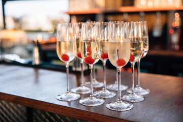 Champagne glasses with cherries at a bar
