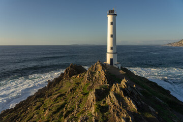 Cabo (cape) Home lighthouse on the cliffs at sunset in Rias Baixas zone in Galicia coast.
