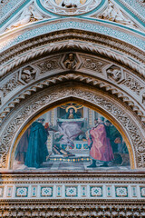 Florence. Italy - 09.06.2025: Close-up of the ornate facade of a historic Florentine cathedral, showcasing intricate mosaic art, religious figures, and detailed marble carvings.