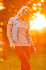 Young woman on field over sunset