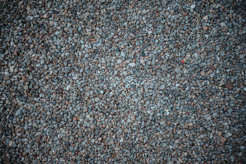 Detailed close-up of natural gravel, showcasing various sizes, shapes, and earthy tones of small stones and aggregate, creating a rugged and versatile texture background.