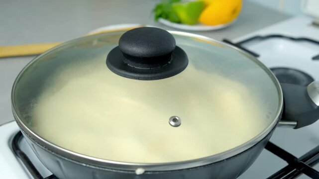 Frying omelet whipped mass in frying pan under lid cooking on kitchen gas stove. Recipe cuisine culinary ingredient. Preparing chicken eggs food dish, super fluffy souffle egg omelet close-up.
