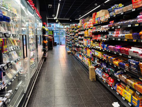 Aisle of grocery SPAR store shelves with wide selection of products and coolers in a modern supermarket