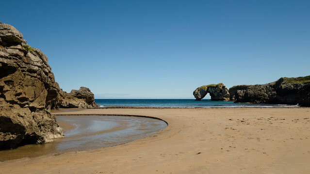 La Huelga beach and the arch-shaped islet Las Gaviotas, also known as Islote Desfuracado, in the eastern coast of Asturias