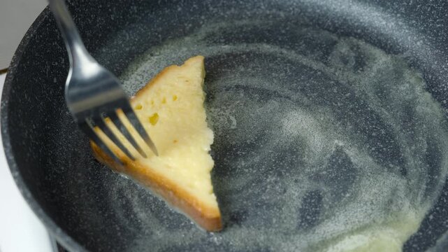 Woman frying bread in egg slices on frying pan cooking toasts on kitchen at home. Cooking tasty homemade domestic meal food dish, hands close-up. Ingredient recipe cuisine culinary.
