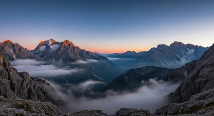 Dramatic mountain peaks piercing through morning clouds offer an inspiring travel destination, showcasing nature's raw beauty and breathtaking landscape