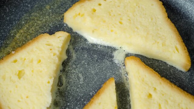Close-up frying bread slice in egg on frying pan cooking toasts on kitchen at home. Cooking tasty homemade domestic meal food dish, hands close-up. Ingredient recipe cuisine culinary.