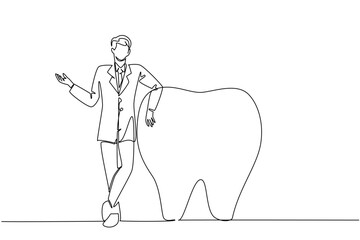 Single continuous line drawing male doctor standing and holding large tooth beside his. Leaning in front of big strong teeth. The specialist. National Dentist Day. One line design vector illustration