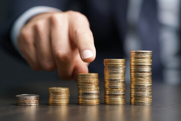 Focused businessman pointing to stack of coin for finance growth
