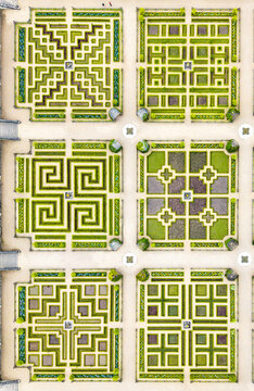 Aerial view of meticulously crafted garden beds display intricate geometric patterns, a symphony of verdant hedges and beige pathways, Villandry, Centre-Val de Loire, France.