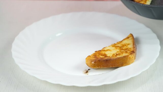 Putting serving frying bread slices on plate from frying pan cooking toasts on kitchen at home. Cook tasty homemade domestic meal food dish, hands close-up. Ingredient recipe cuisine culinary.