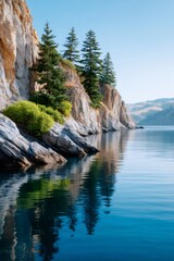Obraz premium Cliffs and pine trees reflecting in calm lake water