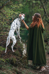 Elven princess walking with Dalmatian dog in enchanted woods
