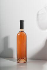 Wine bottle mockup featuring elegant design with amber liquid, minimalist background, and soft shadows, ideal for branding and marketing concepts with copy space