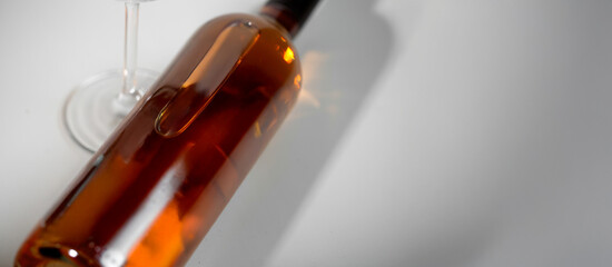 Wine bottle mockup with elegant glass, showcasing rich amber liquid and soft reflections, ideal for branding and design projects with copy space