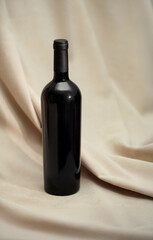 Red Wine bottle mockup displayed on soft beige fabric, showcasing elegant curves and glossy finish, ideal for branding and product presentation with copy space