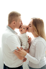 a young family mom and dad holding a newborn baby, hugging and kissing, a happy family with a small child on a white background