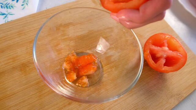 Woman chef hands cutting and deseeding tomatoes in bowl on kitchen at home. Culinary skills techniques, homemade prepare healthy meal, cook domestic food vegetable, cuisine, fresh ingredient.