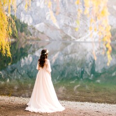 Woman in dress by lake, autumn scene