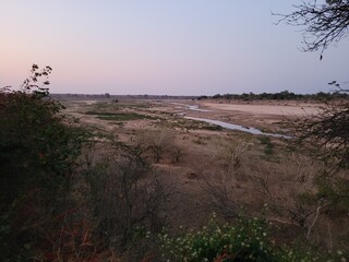 Sunset over Letaba River, Kruger National Park, with tranquil bushveld scenery and soft evening light.