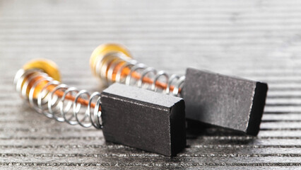 Electric motor brushes on gray background, macro, industry. Copy space for text