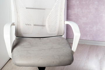 Dirty gray computer chair with stains on upholstery fabric, dry cleaning, close-up