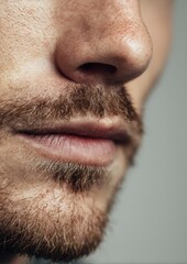 Obraz premium Lifestyle portrait concept: cropped anonymous jawline with mustache, seamless background, editorial-safe, large copy margin left 