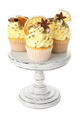Delicious cupcakes with sprinkles and spices on stand isolated on white. Autumn atmosphere