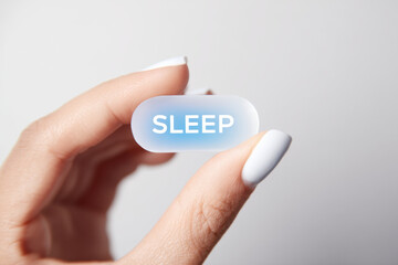 Sleeping Pill Concept: A Hand Holding a Medication for Insomnia and Sleep Aid