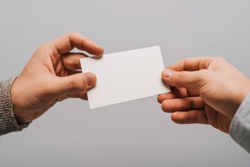 Fototapeta premium Workplace gratitude: anonymous hands giving a blank card, soft office light, neutral background, large copy area, inclusive tone