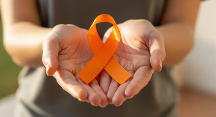 A Symbol of Hope and Awareness Hands Gently Hold an Orange Ribbon Promoting Support and Understanding for Important Causes Worldwide