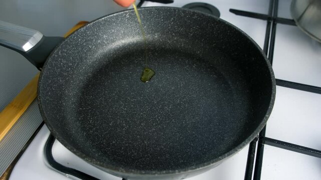 Chef cooking skillfully pouring olive vegetable oil into frying pan on kitchen. Culinary skills techniques, homemade preparing healthy meal, cook domestic food dish cuisine, fresh ingredients.