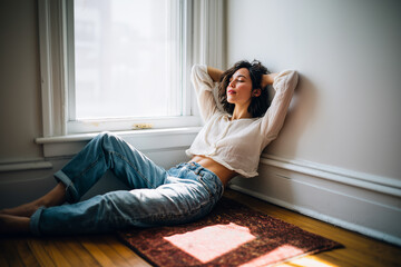 A woman is laying on the floor in a room with a window