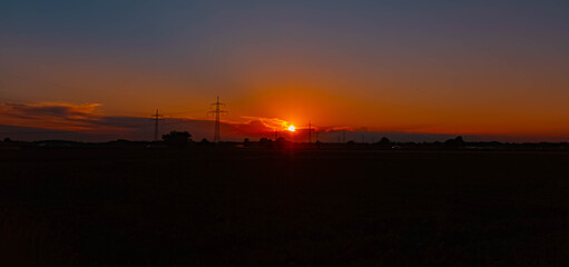 Summer sunset or sundowner with overland high voltage lines near Tabertshausen, Aholming, Deggendorf, Bavaria, Germany