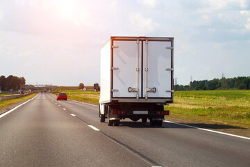 Specialized trucks with a carrying capacity of up to 5 tons transport cargo along the highway in the summer, industry. Copy space for text